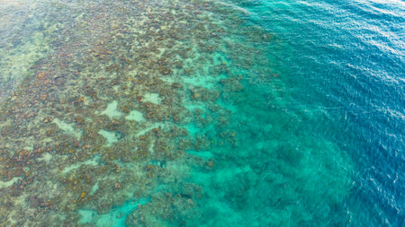 Aerial view of turquoise sea water and coral reef.