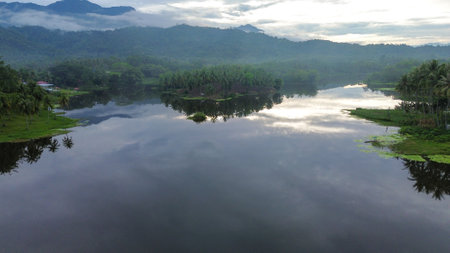 Landscape view of a lake in the morning with clouds and mountains.