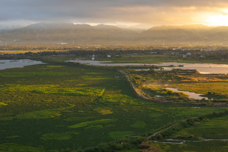Sunrise over a serene landscape with a lake and mountains