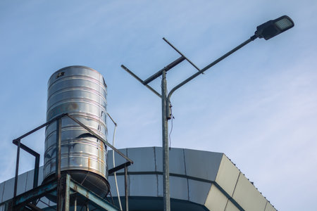 Water Tank and Street Light on Rooftopの写真素材