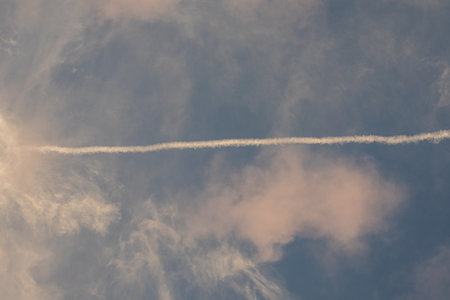 Jet Contrail Across a Cloudy Sky