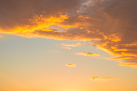 Sunset sky background with orange and yellow clouds. Nature background.