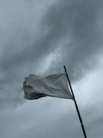 White Flag Waving Against Cloudy Skyの写真素材