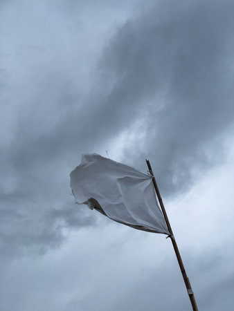 White Flag Waving Against Stormy Skyの写真素材