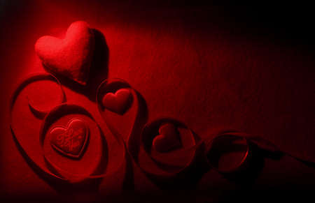 Red hearts with a beautiful shade of red stripe on a red background