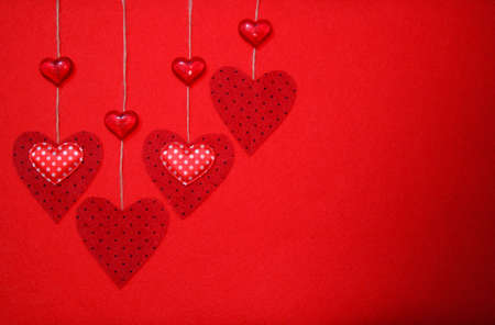 Large red felt hearts on a red background