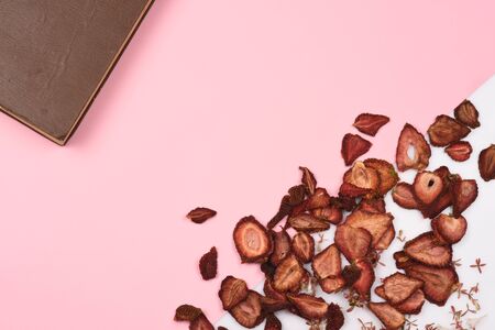 vintage books and dry fruits on pink background