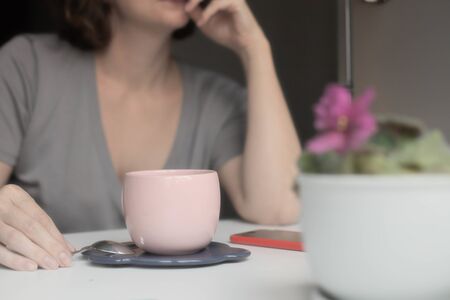 coffee in a pink cup on a background of a girlの写真素材