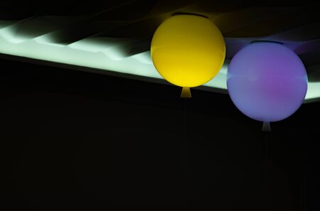 multi-colored lanterns under the ceiling on a dark backgroundの写真素材