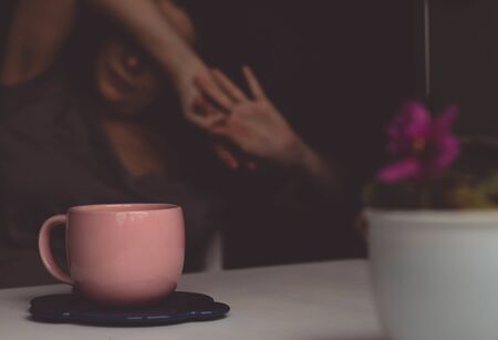 coffee in a pink cup on a background of a girlの写真素材