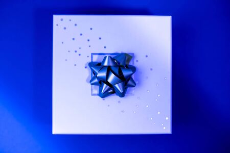 gift box with a bow on a blue background with sparklesの写真素材