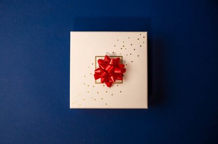 gift box with red bow on a blue backgroundの写真素材