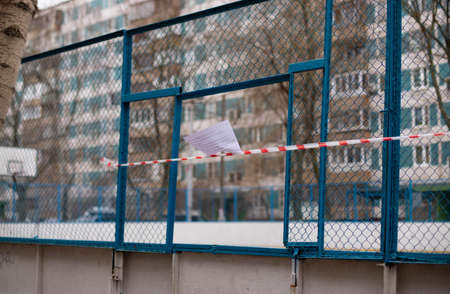 the sports field is fenced with a signal tape. Stay home. Quarantine.のeditorial素材