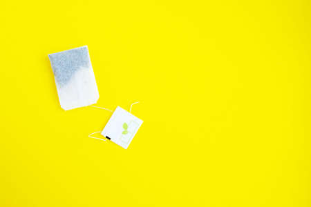 Tea bag on a yellow background. Thread with a tag.の写真素材
