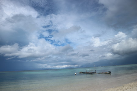 Rusty fishing boat nearly sinking in Masilok Island's beach.の写真素材