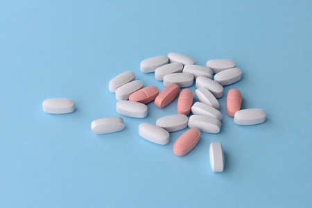 Assorted pharmaceutical medicine pills over blue background