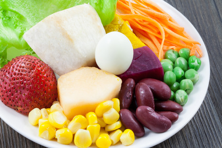 close up vegetables and fruit salad on wood backgroundの写真素材