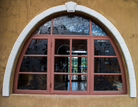 Photo of facade of old house with brown window