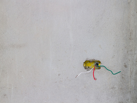 Electrician working in a new building - installing wires and making connectionsの写真素材