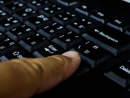 black finger typing on computer black keyboard の写真素材