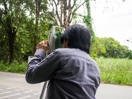 Portrait of builder worker with theodolite transit equipment at construction site outdoors during surveyor workのeditorial素材