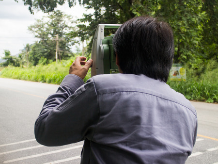 Portrait of builder worker with theodolite transit equipment at construction site outdoors during surveyor workのeditorial素材