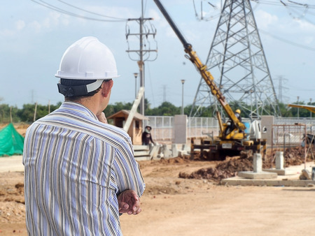 Young engineer looking work in front of construction site