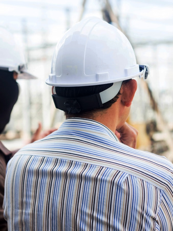 Young engineer looking work in front of construction siteの写真素材