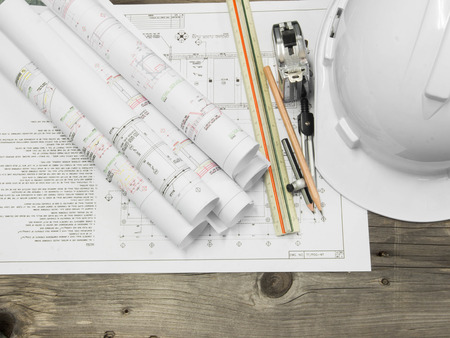 Architectural blueprint of office building with a pencil on wood table