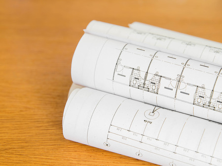 Architectural blueprint of office building with a pencil on wood tableの写真素材