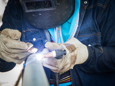 Welder on galvanized pipe in shop at substationの写真素材