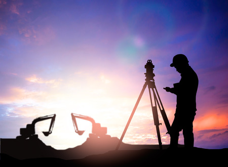 silhouette survey engineer working  in a building site over Blurred construction worker on construction siteの写真素材