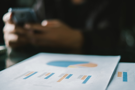 Young businessmen analyze graphs to meet goals set over blurred Business graph on the table in office .Film tones and Light fairの写真素材