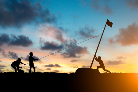 Silhouette team business helps Work together as a team to accomplish your goals to reach the finish line over blurred natural. Motivate employee growth concept.の写真素材