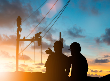 silhouette engineer looking for a job on a high security in a building site over Blurred construction worker on construction site and the natural background.の写真素材