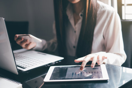 Close up of business woman using tablet and credit card for online shopping.の写真素材