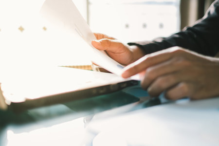 Young businessmen analyze graphs to meet goals set over blurred Business graph on the table in...