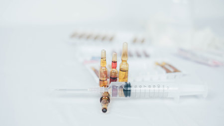 Medical bottle, vials, syringes and face mask on blue background with copy space. Vaccination session and immunity improvement..Vaccination concept. Healthcare, hospital and medical diagnostics.の写真素材