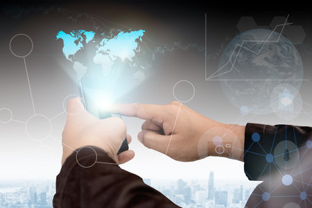 Business,communications,connection,technology concept.businessman using smartphone Show map image holograms. Global Strategy Virtual Icon.Innovation Graphs Interfaces.Analyze market stock over blurred city scape.select focus.flare lightの写真素材