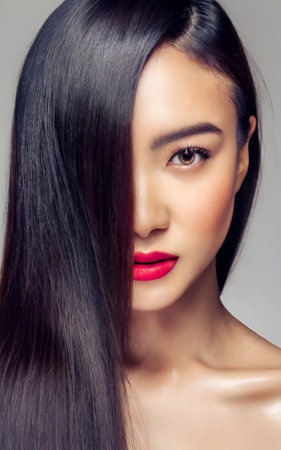 Beautiful young woman with long straight black hair and bright red lips.の素材