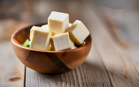 Tofu in a wooden bowl on a wooden background. Selective focus.の素材