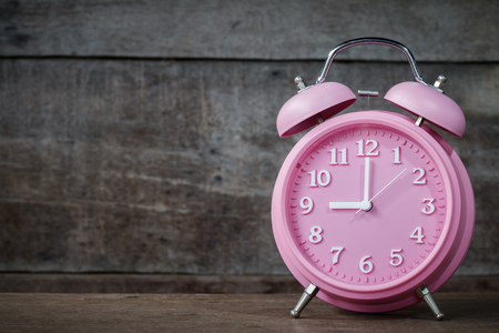 Clock Pink on wooden background with copy spaceの写真素材