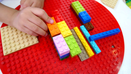 A kid is playing toys. Building blocks and bricks toys.の写真素材