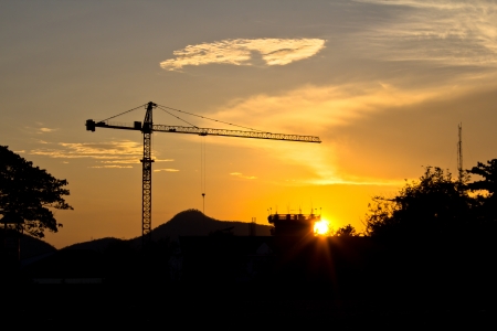 Industrial landscape  Construction cranes and concrete structure at silhouettes sunset  の写真素材