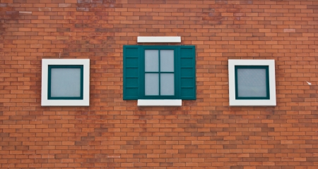 green window on red brick wall の写真素材