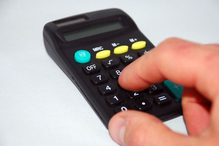 Small personal calculator detail with a finger pressing the equals signの写真素材