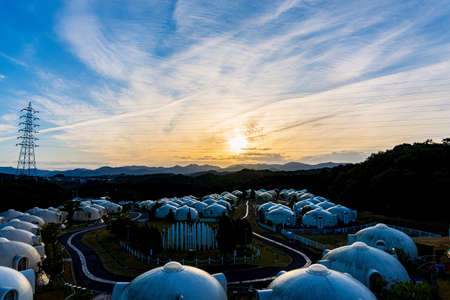 Sunset over a scenic landscape with unique dome-shaped structures.
