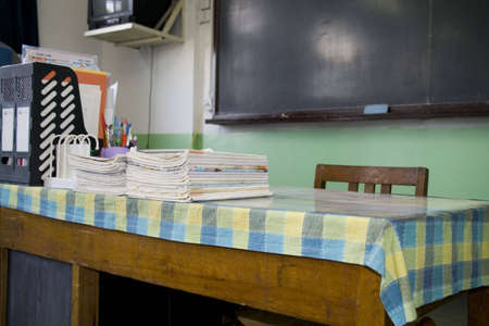 A teacher's desk and a chalkboard in an schoolroom の写真素材