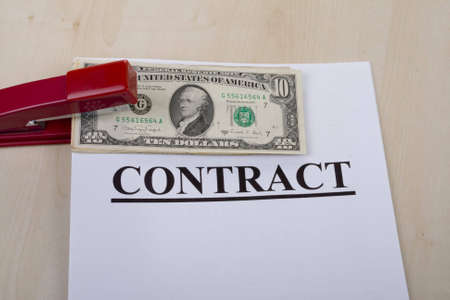 contract and money fastened by a stapler