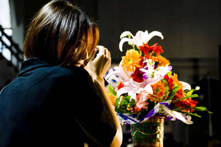 Beautiful  woman and flower basket in the darkの写真素材